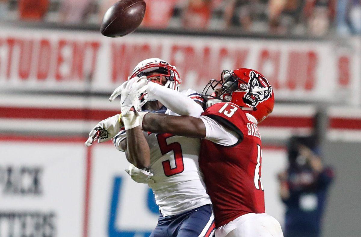 N.C. State defensive back Tyler Baker-Williams (13) breaks up a pass intended for Liberty wide receiver DJ Stubbs (5) during the second half of N.C. State&#8217;s 15-14 victory over Liberty at Carter-Finley Stadium in Raleigh, N.C., Saturday, Nov. 21, 2020.