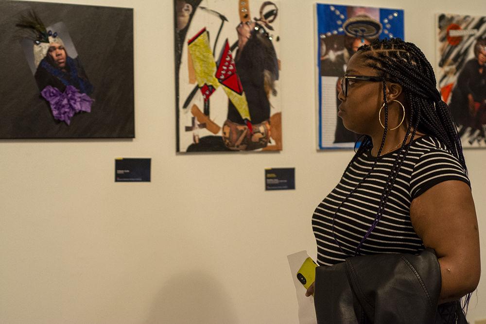 Rasheedah Fletcher, a 2nd year masters student in school counseling, looks at art on display at the Existence as Resistance: The Magic in Blackness exhibit. The exhibit opened on Feb. 18, 2020 in the African American Cultural Center Art Gallery.