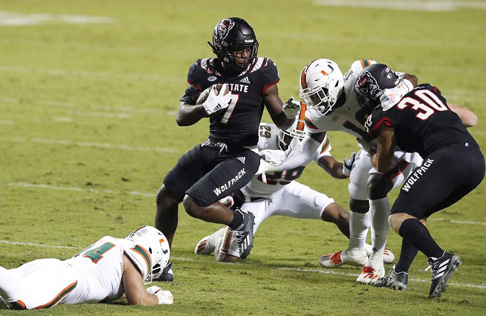 N.C. State running back Zonovan 'Bam' Knight (7) spins around Miami defenders during his 100-yard kickoff return for a touchdown in the second half of Miami&#8217;s 44-41 victory over N.C. State at Carter-Finley Stadium in Raleigh, N.C., Friday, Nov. 6, 2020.
