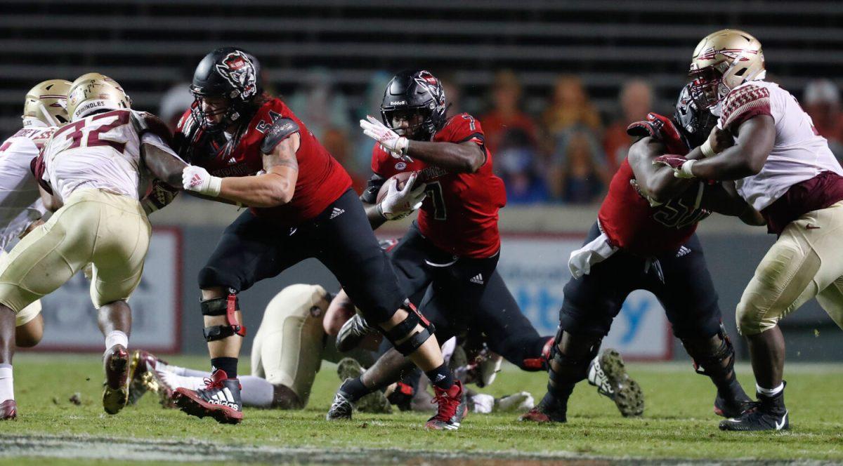 N.C. State running back Zonovan 'Bam' Knight (7) goes through the hole opened up by Dylan McMahon (54), left, and Grant Gibson (50) during the second half of N.C. State&#8217;s 38-22 victory over Florida State at Carter-Finley Stadium in Raleigh, N.C., Saturday, Nov. 14, 2020.