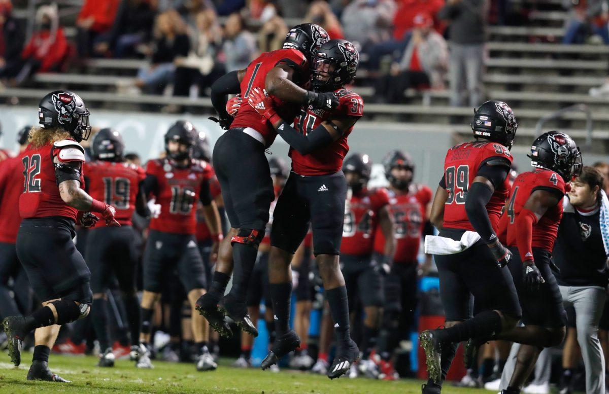 N.C. State linebacker Isaiah Moore (1) celebrates with Vi Jones (31) after forcing Florida State to turnover the ball on downs during the first half of N.C. State&#8217;s game against Florida State at Carter-Finley Stadium in Raleigh, N.C., Saturday, Nov. 14, 2020.