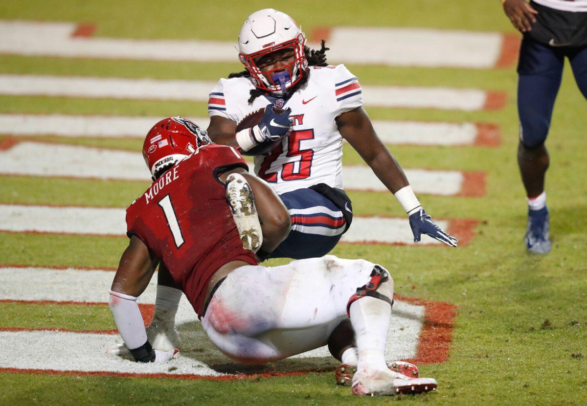N.C. State linebacker Isaiah Moore (1) tackles Liberty running back Peytton Pickett (25) in the end zone for a safety during the second half of N.C. State&#8217;s 15-14 victory over Liberty at Carter-Finley Stadium in Raleigh, N.C., Saturday, Nov. 21, 2020.