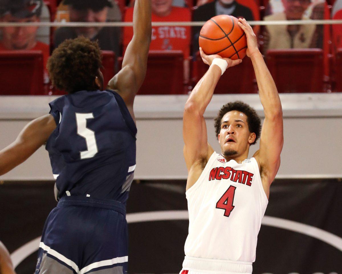 N.C. State's Jericole Hellems (4) shoots as North Florida's Dorian James (5) defends during the first half of N.C. State&#8217;s game against North Florida in the Mako Medical Wolfpack Invitational at Reynolds Coliseum in Raleigh, N.C., Friday, Nov. 27, 2020.