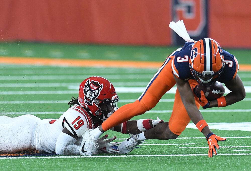 North Carolina State Wolfpack defensive back Joshua Pierre-Louis (19) tackles Syracuse Orange wide receiver Taj Harris (3) during a game on Saturday, Nov. 28, 2020, at the Carrier Dome in Syracuse, N.Y. Dennis Nett |dnett@syracuse.com