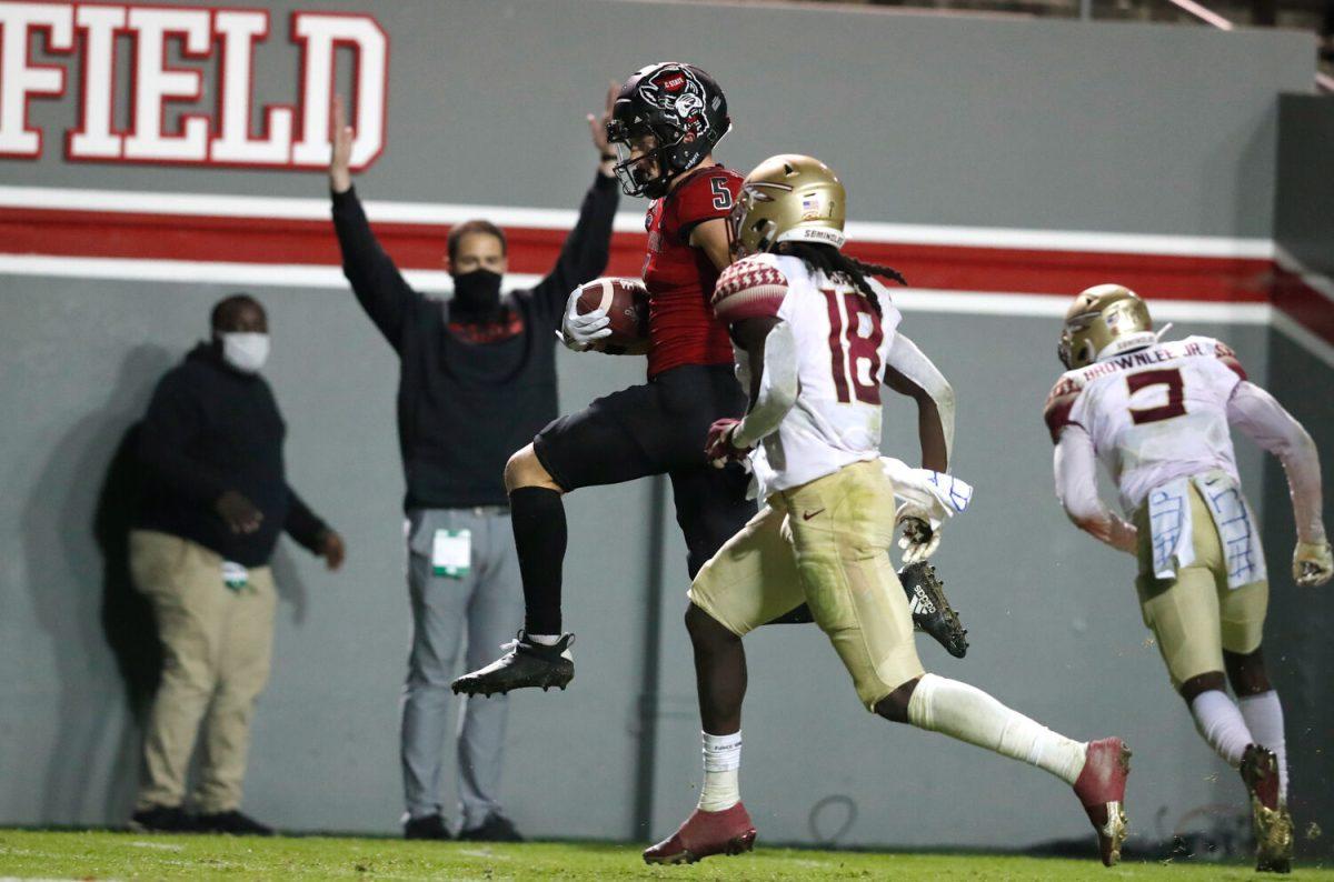 N.C. State wide receiver Thayer Thomas (5) heads into the end zone in front of Florida State defensive back Travis Jay (18) on 24-yard touchdown reception during the second half of N.C. State&#8217;s 38-22 victory over Florida State at Carter-Finley Stadium in Raleigh, N.C., Saturday, Nov. 14, 2020.