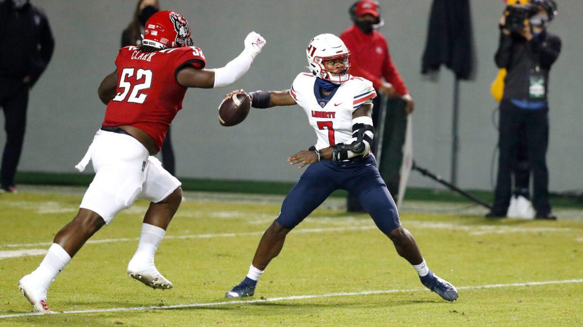 Liberty quarterback Malik Willis (7) prepares to pass as N.C. State defensive tackle C.J. Clark (52) closes in during the first half of N.C. State&#8217;s game against Liberty at Carter-Finley Stadium in Raleigh, N.C., Saturday, Nov. 21, 2020.