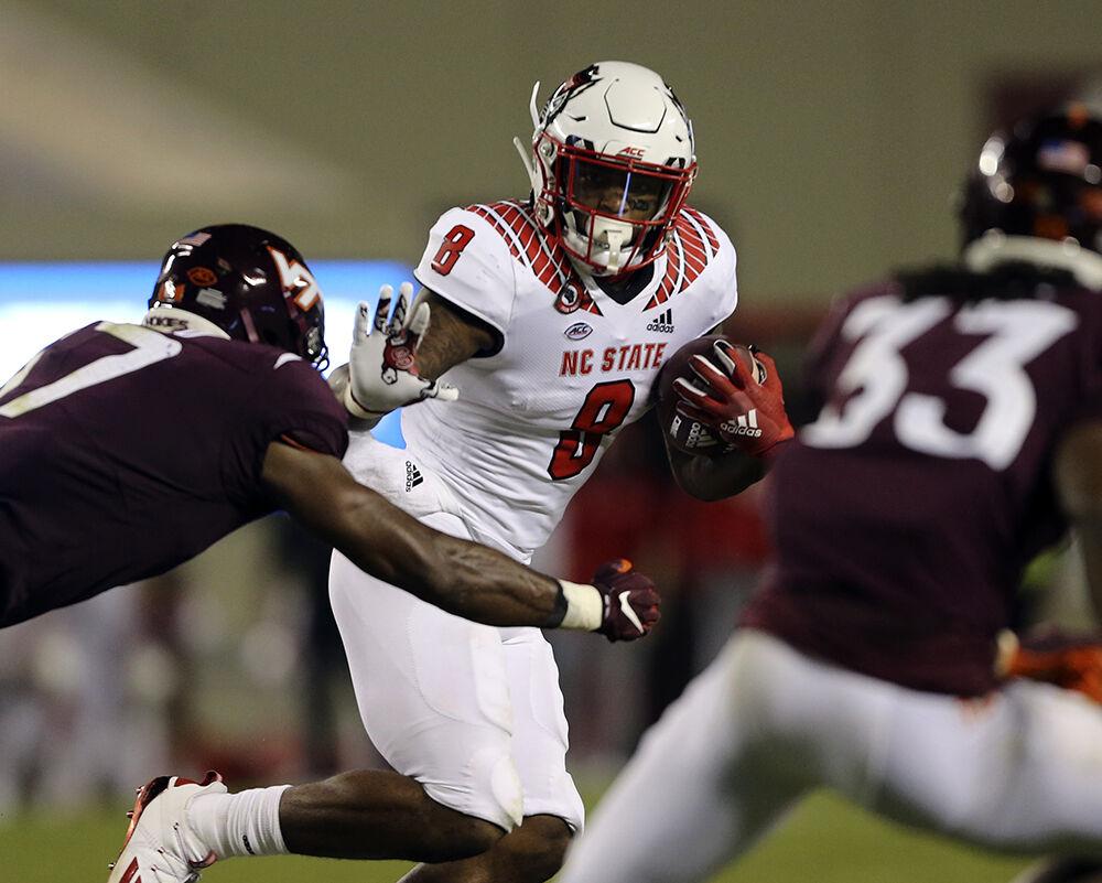 NC State running back Ricky Person, Jr. 8 runs the ball while chased by Virginia Tech defender Divine Deablo 17 and Keonta Jenkins 33 during the second quarter of the Virginia Tech - North Carolina State NCAA football game in Blacksburg Va. Saturday September 26 2020. (AP Photo / The Roanoke Times, Matt Gentry, Pool)