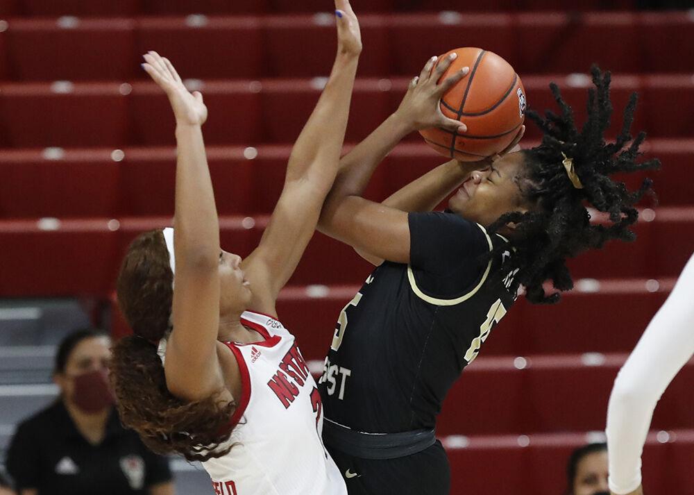 Wake Forest's Nevaeh Brown (15) shoots as NC State's Kai Crutchfield (3) defends during the first half of N.C. State&#8217;s game against Wake Forest at Reynolds Coliseum in Raleigh, N.C., Thursday, Dec. 17, 2020.