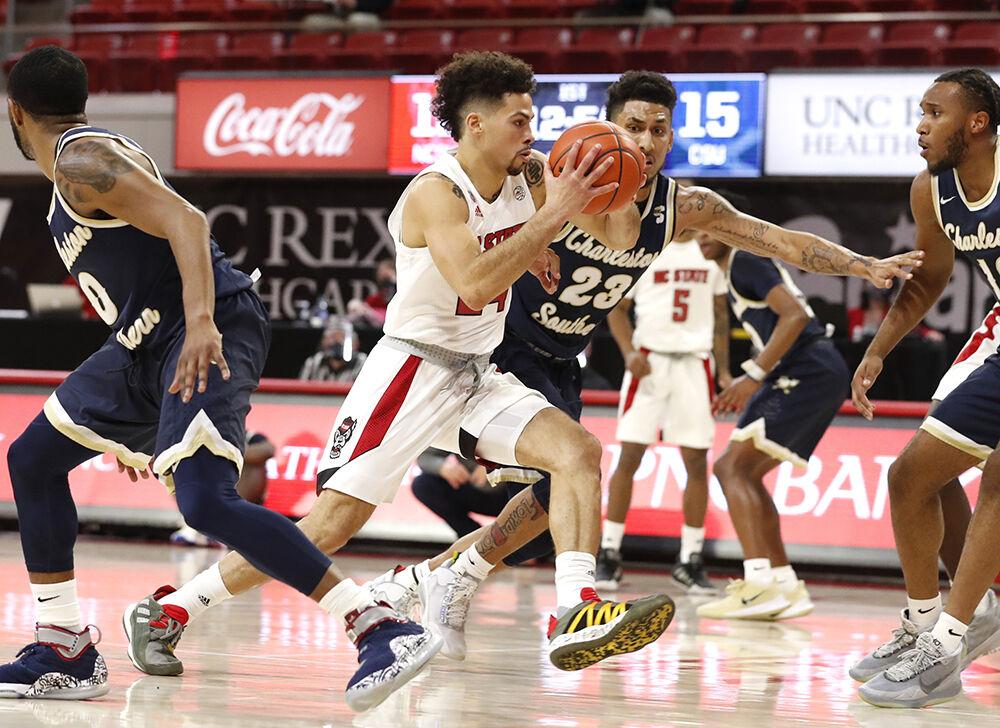 N.C. State's Devon Daniels (24) drives past Charleston Southern's Sean Price (23) during N.C. State&#8217;s game against Charleston Southern in the Wolfpack Invitational at Reynolds Coliseum in Raleigh, N.C., Wednesday, Nov. 25, 2020.