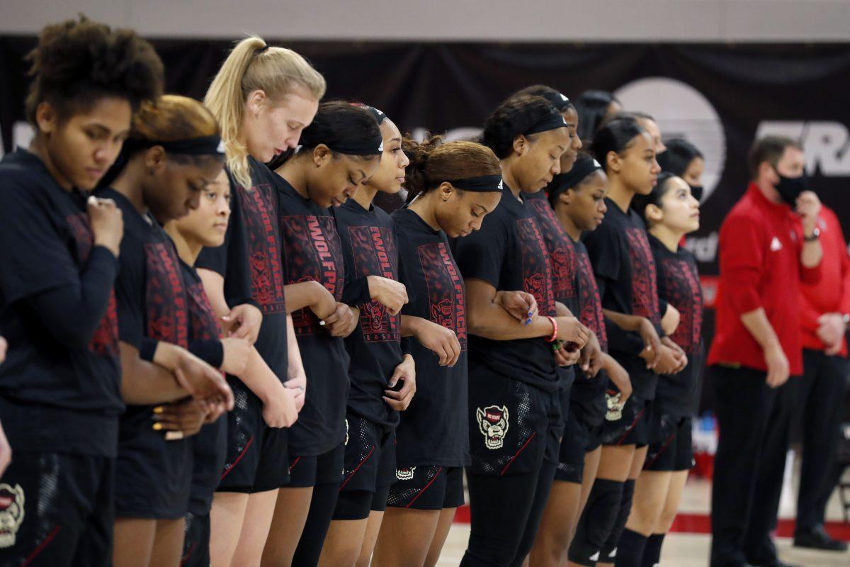 Members of the N.C. State team locked arms during the national anthem before the Wolfpack&#8217;s game against Miami at Reynolds Coliseum in Raleigh, N.C., Sunday, Dec. 20, 2020.