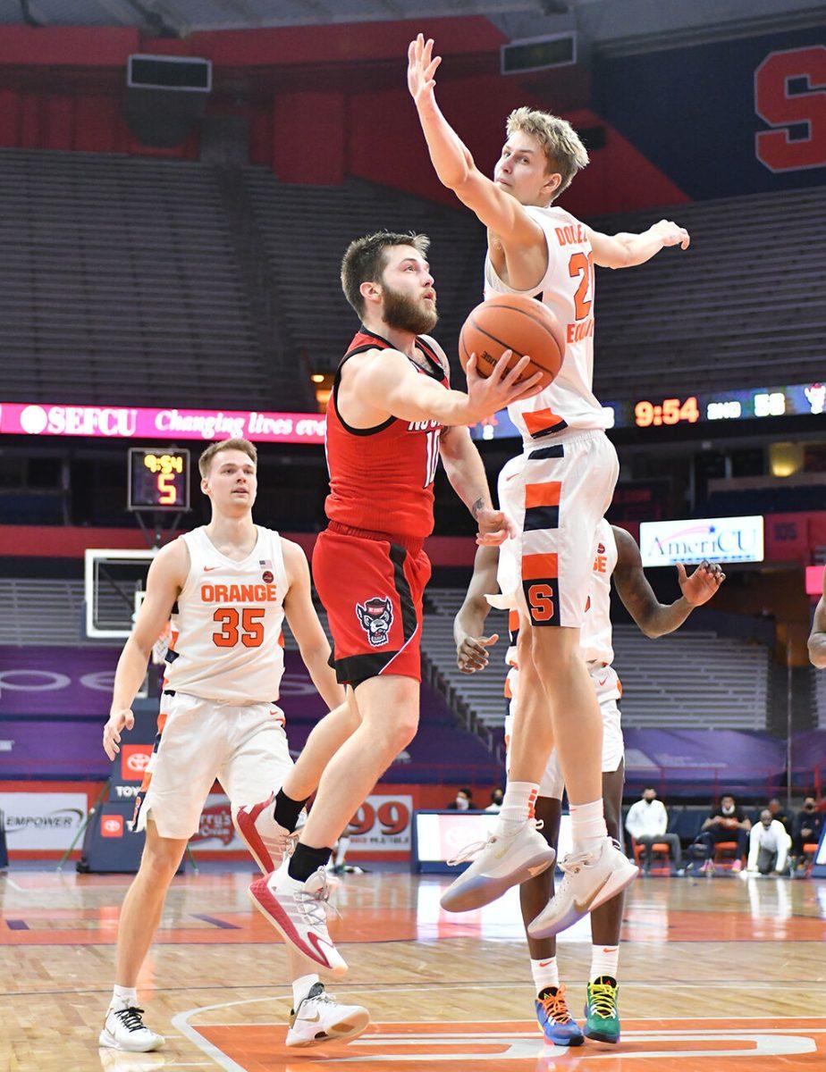 Jan 31, 2021; Syracuse, New York, USA; North Carolina State Wolfpack guard Braxton Beverly (10) attempts a shot as Syracuse Orange forward Marek Dolezaj (21) and guard Buddy Boeheim (35) defend in the second half at the Carrier Dome. Mandatory Credit: Mark Konezny-USA TODAY Sports