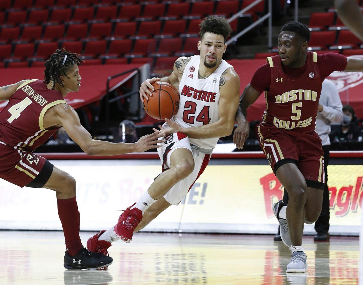 N.C. State's Devon Daniels (24) drives between Boston College's Makai Ashton-Langford (4) and Jay Heath (5) during the second half of N.C. State&#8217;s 79-76 victory over Boston College at PNC Arena in Raleigh, N.C., Wednesday, December 30, 2020.