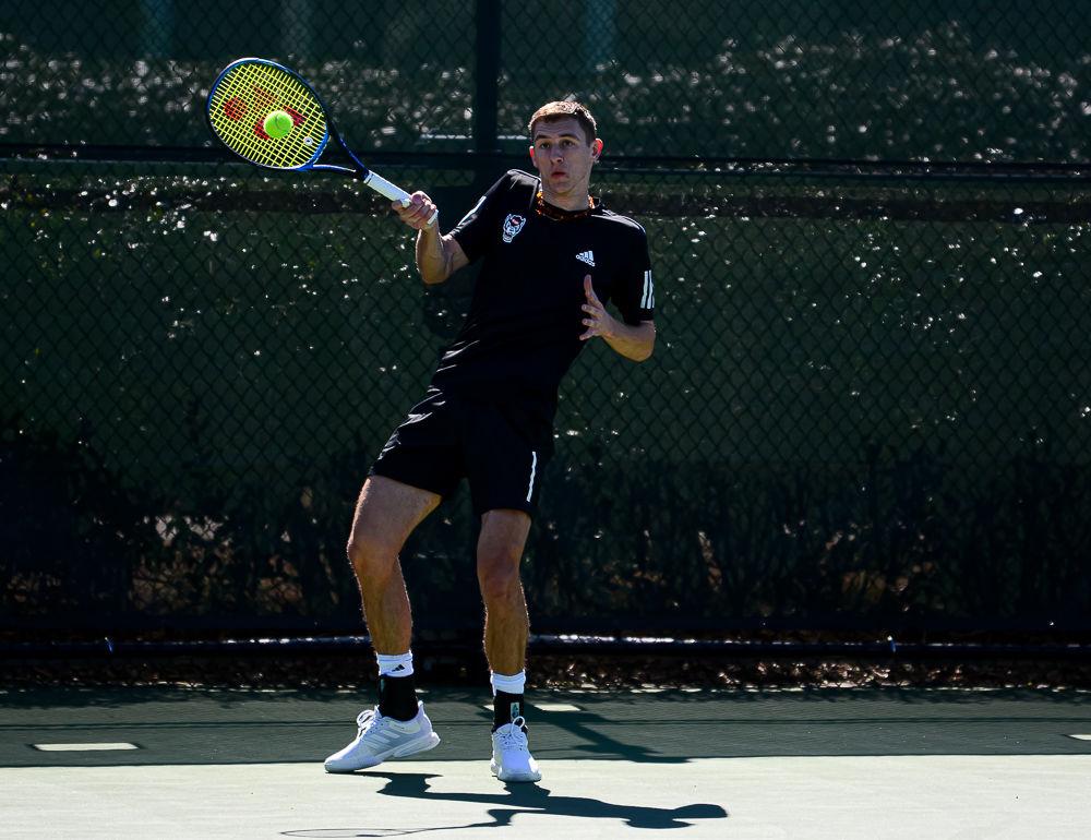 Junior Tadas Babelis returns the ball against Texas on Sunday, March 1 at Cary Tennis Park. Babelis' doubles match with sophomore Yannai Barkai went unfinished and Babelis lost his singles match 6-1, 6-2, but the Wolfpack ended up with a 4-3 team win.