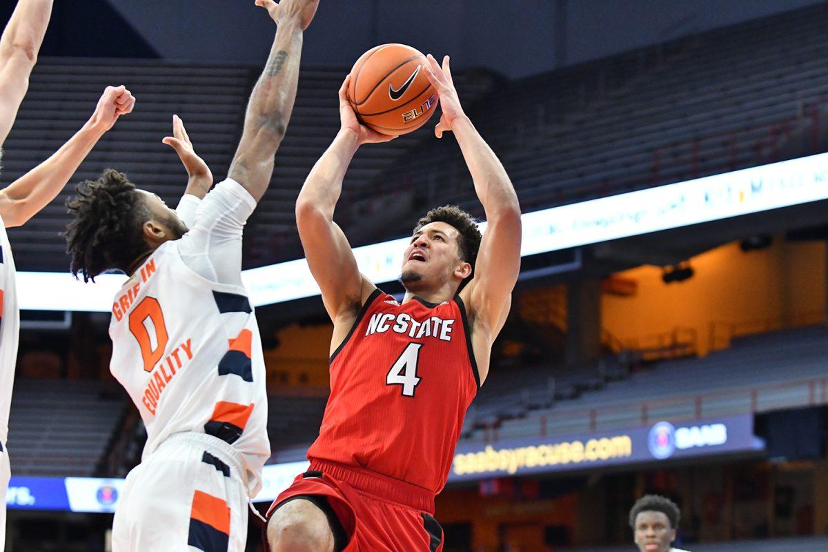 Jan 31, 2021; Syracuse, New York, USA; North Carolina State Wolfpack forward Jericole Hellems (4) takes a shot over the defense of Syracuse Orange forward Alan Griffin (0) in the second half at the Carrier Dome. Mandatory Credit: Mark Konezny-USA TODAY Sports