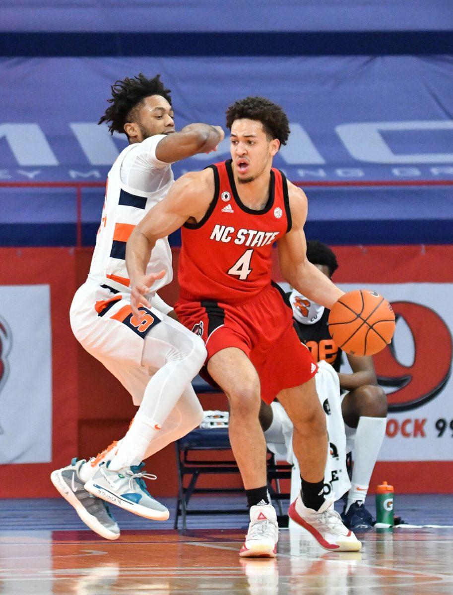 Jan 31, 2021; Syracuse, New York, USA; North Carolina State Wolfpack forward Jericole Hellems (4) tries to get the ball past Syracuse Orange forward Alan Griffin (0) in the first half at the Carrier Dome. Mandatory Credit: Mark Konezny-USA TODAY Sports