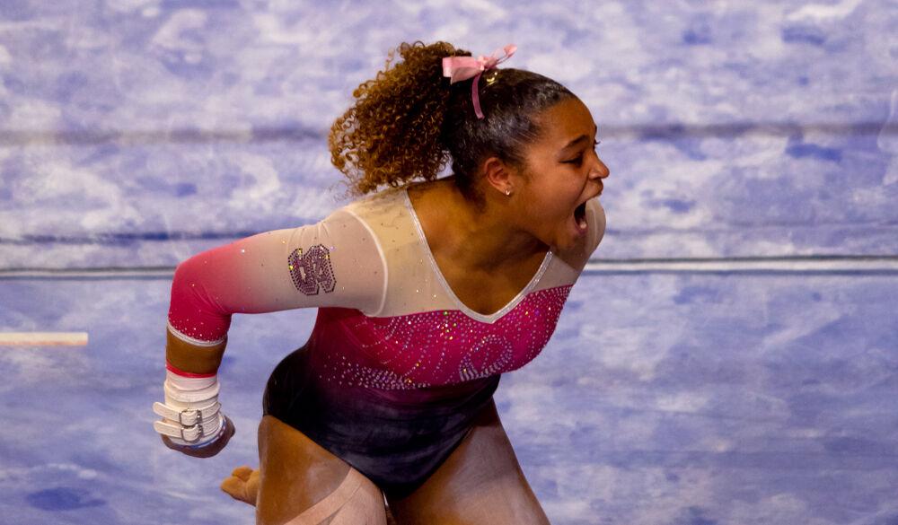 Freshman Carina Jordan celebrates a successful uneven bars routine on Saturday, Feb. 6, 2021 at Reynolds Coliseum. Jordan scored a 9.850 on the bars to tie for first place in the event. The Wolfpack won the quad-meet over UNC-Chapel Hill, Pitt and Towson with a score of 196.025.