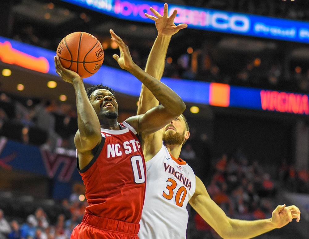 Redshirt sophomore forward DJ Funderburk goes up for a shot while guarded by Virginia forward Jay Huff during the ACC Tournament game on Thursday, March 14, 2019 in the Spectrum Center. Funderburk scored 12 points and shot 4-6 against the Cavaliers. The Wolfpack lost to Virginia 76-56.