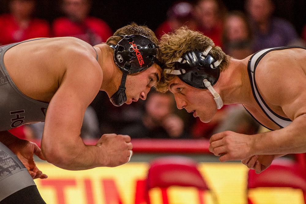 Redshirt freshman Trent Hidlay butts heads with Virginia Tech&#8217;s Hunter Bolen on Friday, Feb. 14 at Reynolds Coliseum. While Hidlay lost his individual match 1-3, the Wolfpack came away with the team victory with an overall score of 21-18.