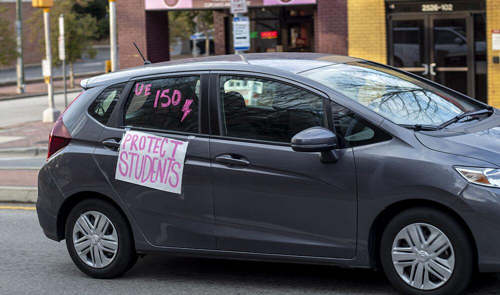 A car that reads "UE 150" and "Protect Students" drives up and down Hillsborough street with other cars with similar signs on Wednesday, Feb. 10, 2021.
