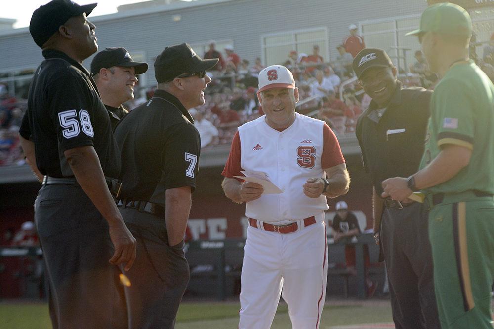 Head coach Elliott Avent shares a laugh with the umpires and Notre Dame head coach Mik Aoki before the game on Friday, April 13 at Doak Field. Notre Dame won the opening game of the series 12-8.