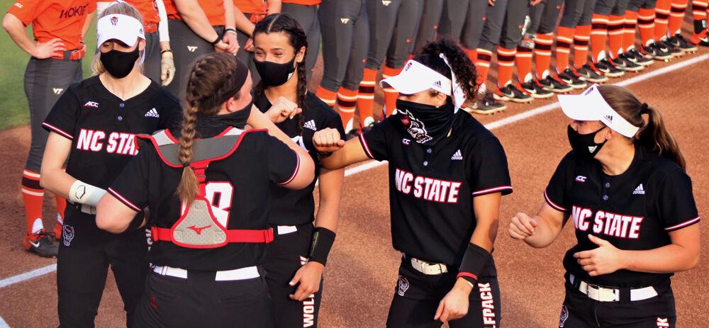 NCSU teammates fist bump with redshirt junior catcher, Sam Sack, as she is called on the field. Sack had 3 putouts in the game against Virginia Tech. The Wolfpack lost 2-4 on Friday, Mar. 12 at Dail Softball Field.