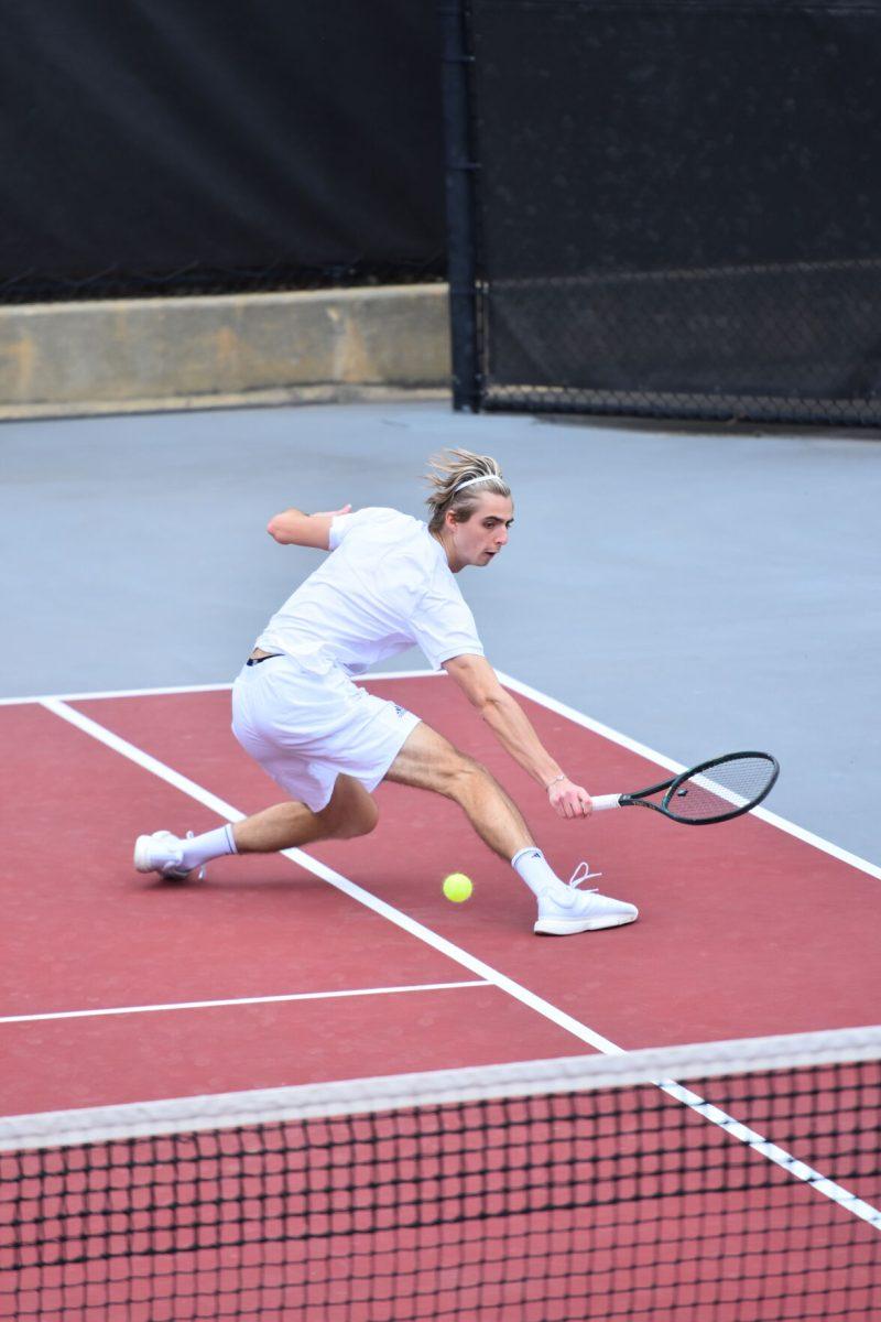 Sophomore Robin Catry slides into a backhand on Saturday, March 13, 2021 at J.W. Isenhour Tennis Center. NC State won the match against the Miami Hurricanes 4-1.