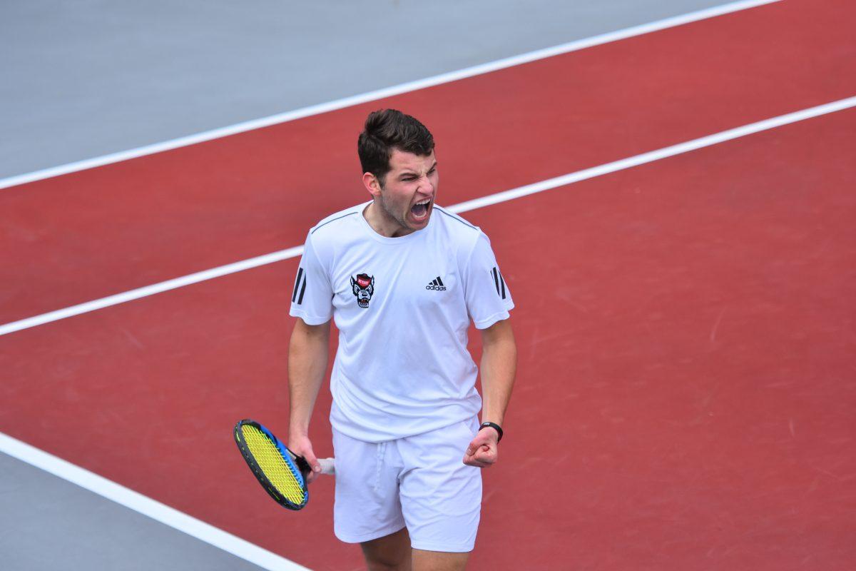 Sophomore Martin Rocens celebrates after hitting a game winning point on Saturday, March 13, 2021 at J.W. Isenhour Tennis Center. NC State won the match against the Miami Hurricanes 4-1.