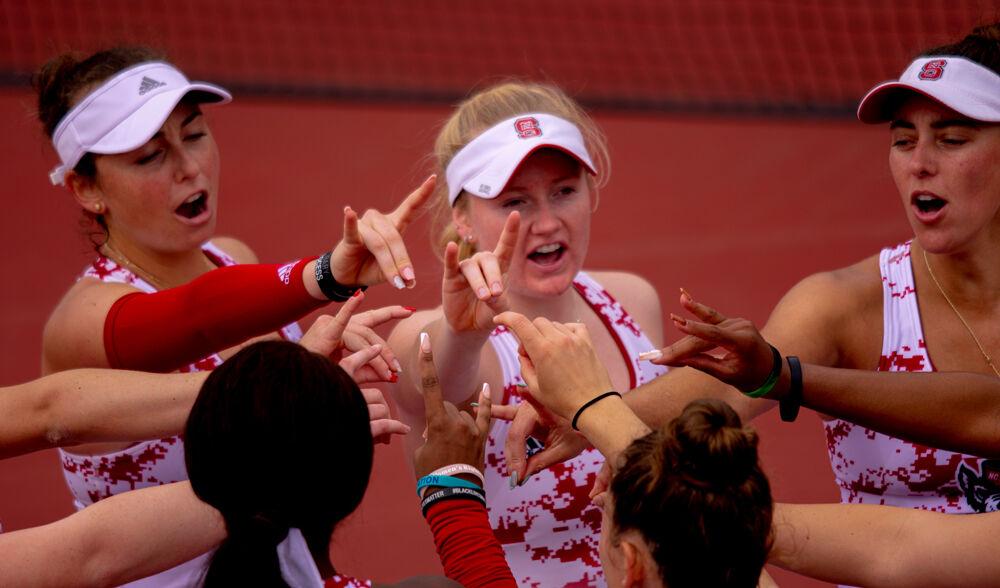 Freshman Abigail Rencheli, senior Lexi Keberle and fifth-year Adriana Reami break down a huddle before playing UNC-Charlotte on Wednesday, March 24, 2021 at J.W. Isenhour Tennis Center. The Wolfpack won 5-0.