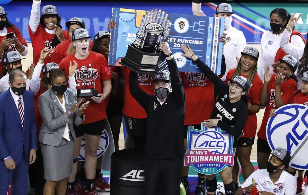 N.C. State head coach Wes Moore holds up the championship trophy after N.C. State&#8217;s 56-54 victory over Louisville in the finals of the ACC Women&#8217;s Basketball Tournament in Greensboro, N.C., Sunday, March 7, 2021.