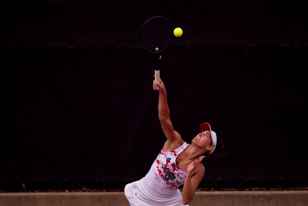 Fifth-year Adriana Reami serves against UNC-Charlotte on Wednesday, March 24, 2021 at J.W. Isenhour Tennis Center. Reami won her doubles match with senior Jaeda Daniel 6-0 to help the Wolfpack to a 5-0 victory.