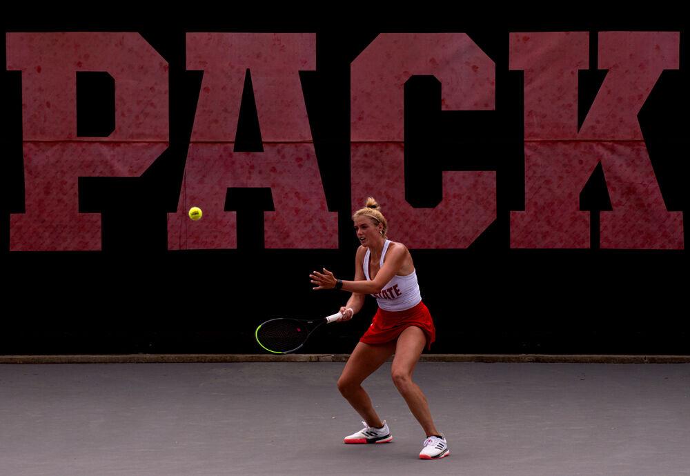 Fifth-year Anna Rogers returns the ball against No. 12 Virginia on Sunday, April 11, 2021 at J.W. Isenhour Tennis Center. Rogers&#8217; doubles match with junior Alana Smith went unfinished and Rogers lost her singles match 6-2, 3-6, 6-2. The Wolfpack won 4-3.