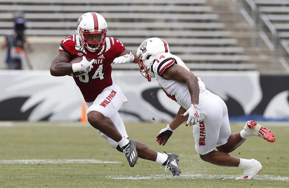 N.C. State running back Delbert Mimms III (34) tries to escape from safety Nehki Meredith (14) during the first half of N.C. State football&#8217;s spring game at Carter-Finley Stadium in Raleigh, N.C., Saturday, April 10, 2021.