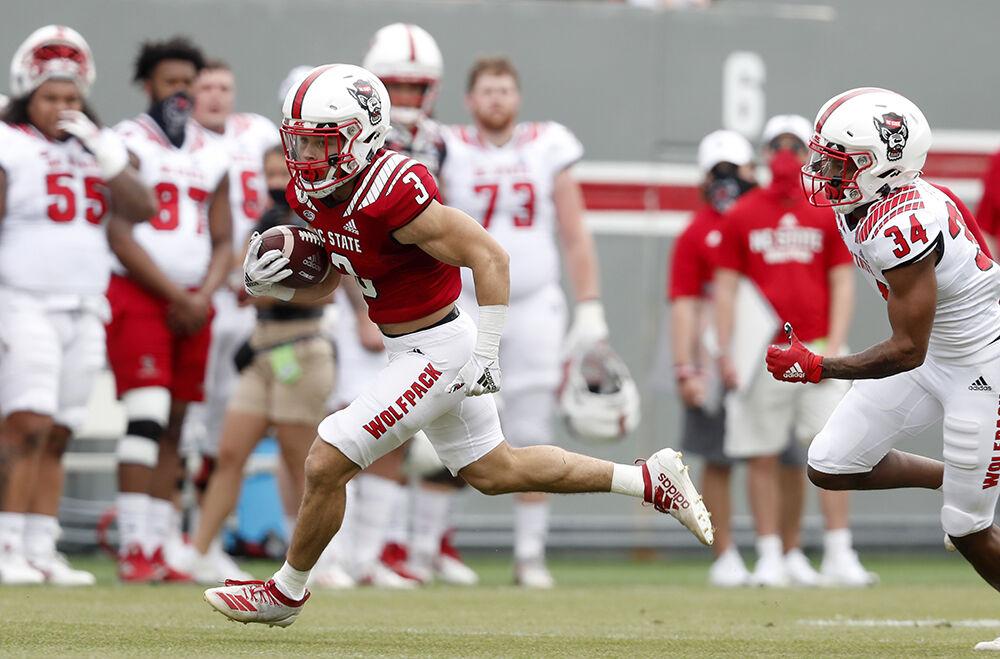 N.C. State running back Jordan Houston (3) runs past N.C. State cornerback Nate Evans (34) during the first half of N.C. State football&#8217;s spring game at Carter-Finley Stadium in Raleigh, N.C., Saturday, April 10, 2021.