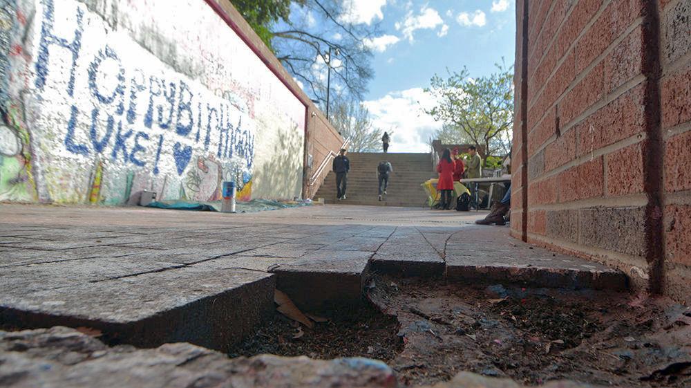 A hole created by missing bricks sits outside the Free Expression Tunnel on March 14, 2017. Holes like this one pop up across the campus due to students taking bricks as keepsakes, and the gaps in the walkways can sometimes grow to be rather large. Stealing a brick, while not an official tradition of the university, is a well-known practice among students.