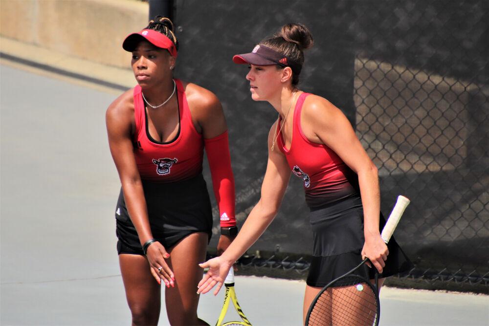 Senior Jaeda Daniel and 5th year Adriana Reami tap each other for a "good job" after winning a point in their doubles against Virginia Tech at J.W. Isenhour Tennis Center on Friday, April 9th, 2021. NCSU won 7-0.
