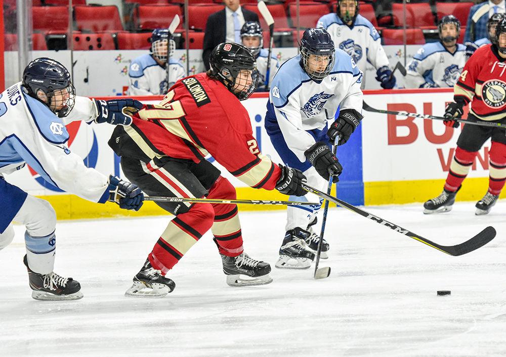 Icepack hockey player Chris Solomon, a freshman studying business administration, stick handles the puck through two UNC defenders on Monday, Nov. 25, 2019 in PNC Arena. The Icepack beat the Tarheels 8-6.