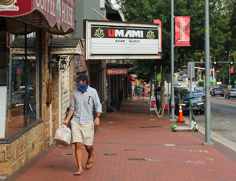 A customer walks down Hillsborough Street after picking up take out on Monday, Aug. 10, 2020.