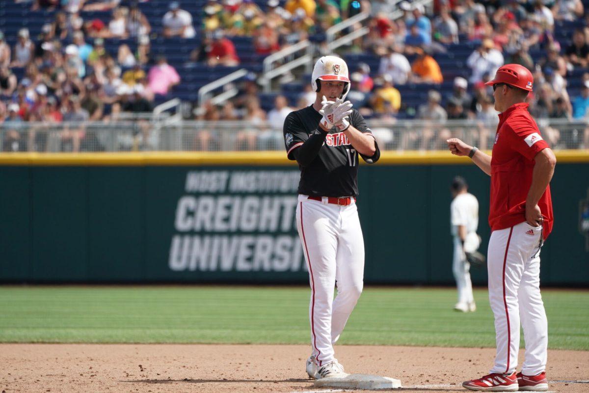 OMAHA, NE &#8212; Freshman pitcher Sam Highfill claps after reaching base against Vanderbilt on June 25, 2021. Highfill, playing at first base due to NC State's limited roster, recorded three hits from four plate appearances.
