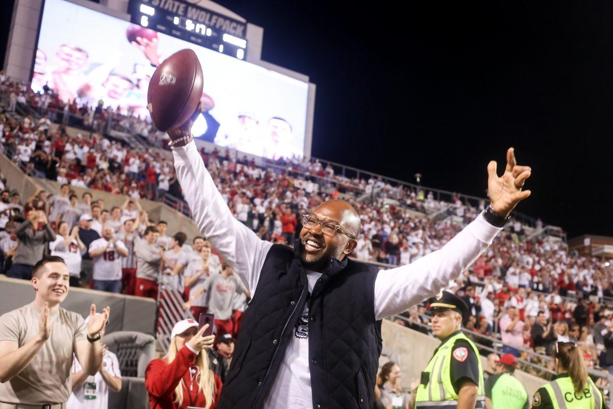 Former NC State wide receiver Torry Holt celebrates his induction into the College Hall of Fame by catching one final pass in Carter-Finley Stadium from fellow Wolfpack alum Mike Glennon during a stoppage in play of the Wolfpack's 16-10 home win against the Syracuse Orange on Thursday, October 10, 2019. Holt will be inducted on Dec. 10, 2019, after a distinguished career at NC State where he still holds numerous ACC records, and an 11-year career in the NFL with multiple All Pro seasons and a Super Bowl championship. His senior season of 1998, he totaled 1,604 receiving yards, and his average of 145.8 yards per game is over 20 yards better than any other receiver in ACC history.