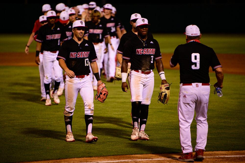 Head coach Elliott Avent (9) congratulates his players after the win against No. 16 Florida State on Friday, May 21, 2021 at Doak Field. The Wolfpack won 6-4.