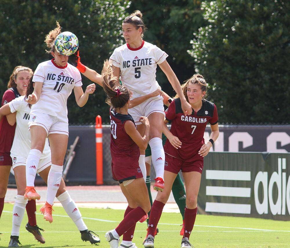 NC State freshman Annika Wohner (10) heads the ball clear on a corner attempt by South Carolina while junior Jenna Butler (5) defends during the NC State Wolfpack's soccer match against the South Carolina Gamecocks at the Dail Soccer Field on Saturday, August 29, 2021. The Wolfpack lost the match 2-1 on a last-minute score by the Gamecocks.