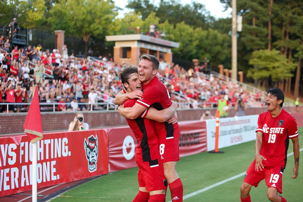 Freshman midfielder Luke Hille (17) celebrates with graduate student Brad Sweeney (8) after Hille scored the first goal of the soccer match against UNC Asheville at Dail Soccer Field on Monday, August 30, 2021. The Pack beat the Bulldogs 4-0.