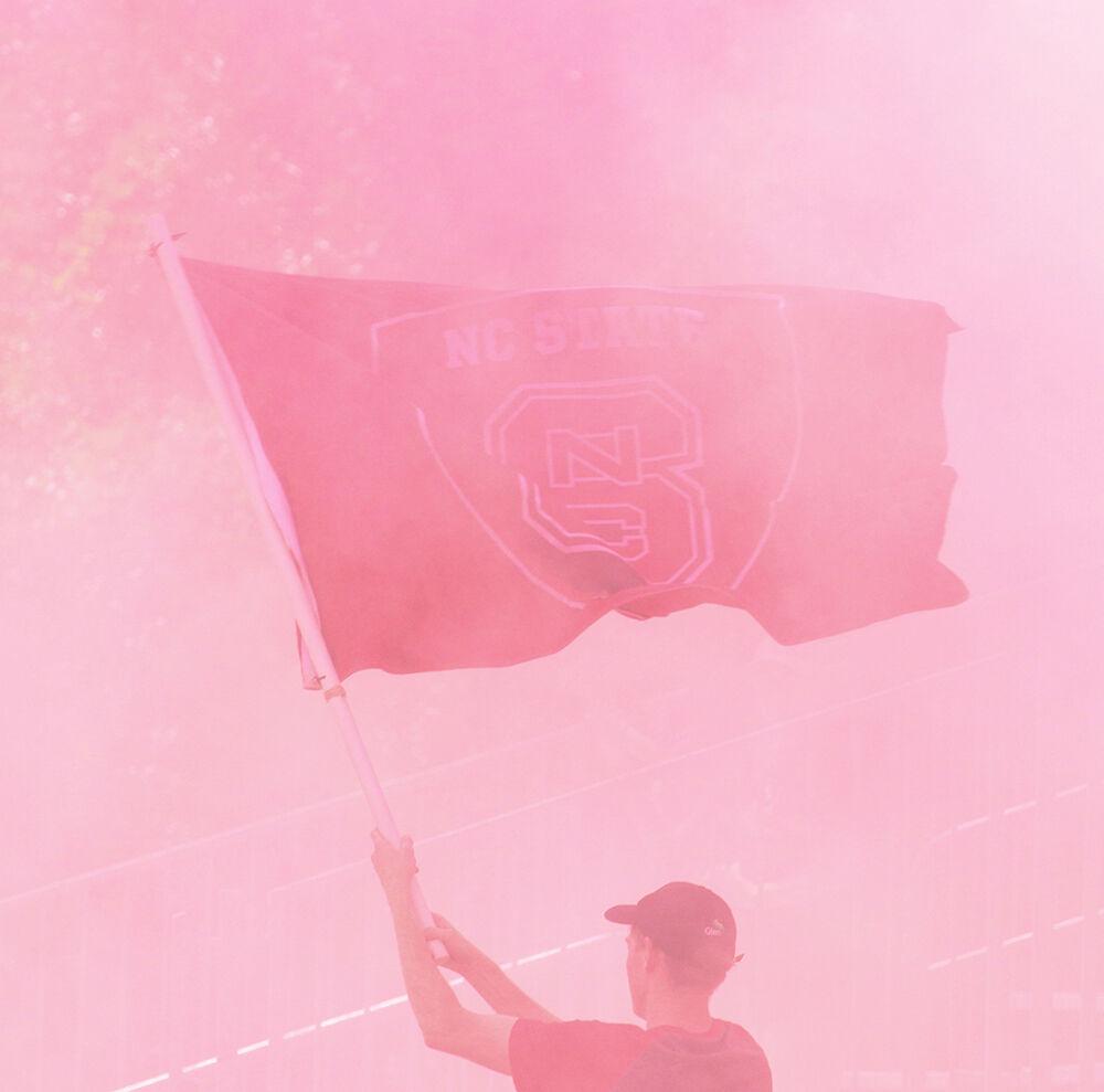 The NC State student section waves a flag during the NC State Wolfpack's soccer match against the South Carolina Gamecocks at the Dail Soccer Field on Saturday, August 29, 2021. The Wolfpack lost the match 2-1 on a last-minute score by the Gamecocks.