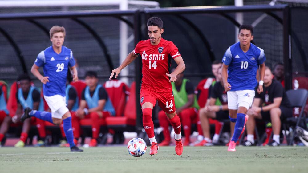 Freshman forward Henrique Santos dribbles between the opposing players. Santos had a goal and an assist in the 4-0 win over UNC Asheville on Monday, Aug. 30, 2021.
