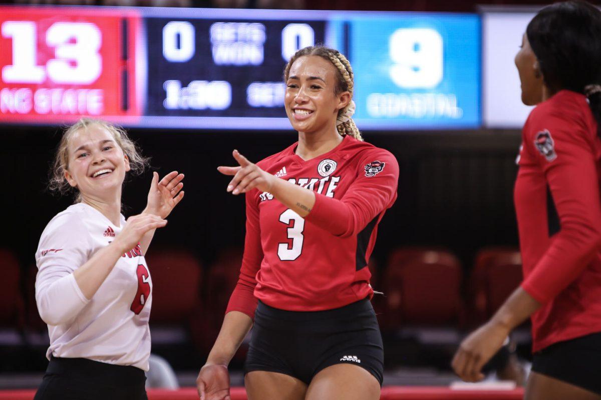 NC State graduate student Melissa Evans (3) points out a good pass from a teammate after notching a kill during the Wolfpack's exhibition game against the Coastal Carolina Chanticleers in Reynolds Coliseum on Saturday, August 21, 2021. Coastal Carolina defeated the Wolfpack 3-1 in the exhibition match, their first match of the season.