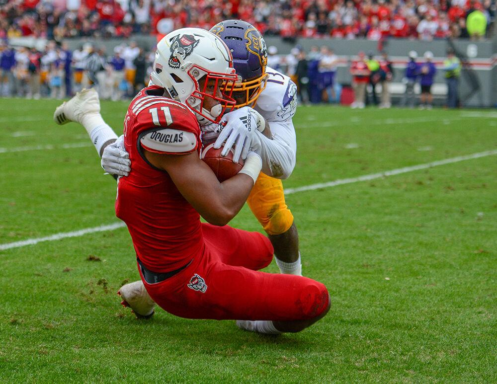 Redshirt junior wide receiver Jakobi Meyers protects the ball while being tackled by an ECU defender on Saturday, Dec. 1, 2018 in Carter-Finley Stadium. Meyers broke the NC State record for most catches in a season in the game versus the Pirates. The Wolfpack beat the Pirates 58-3.