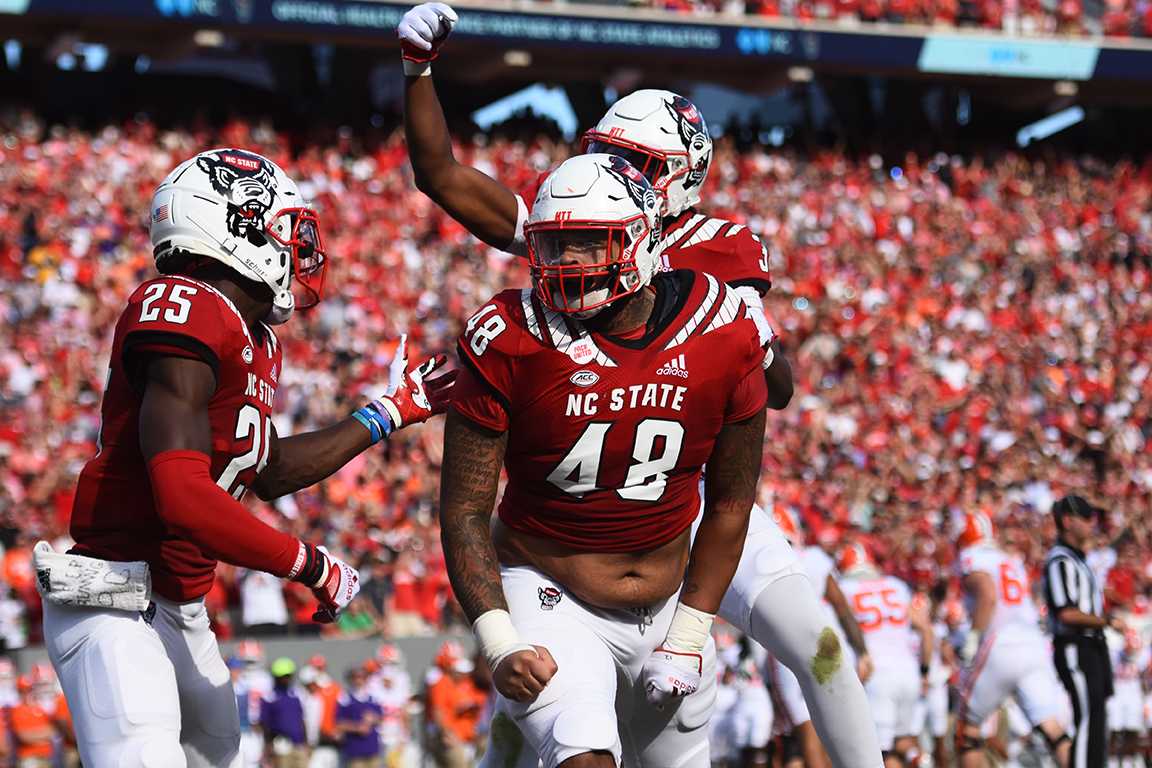 Graduate Cory Durden celebrates with teammates after sacking the Clemson quarterback in Carter-Finley Stadium on Saturday, Sept. 25, 2021. Durden had 1.5 sacks with a 7 sack yardage. The Wolfpack beat Clemson 27-21 in double overtime. This win defeated the losing-streak.