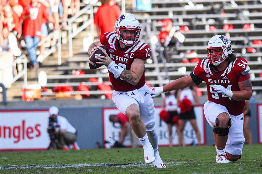 Redshirt sophomore quarterback Devin Leary rushes the ball with redshirt freshman offensive lineman Dylan McMahon protecting him on Saturday, Sept. 25, 2021 in Carter-Finley Stadium. Leary had 7 total rushing yards. The Wolfpack beat the Tigers in double overtime 27-21.