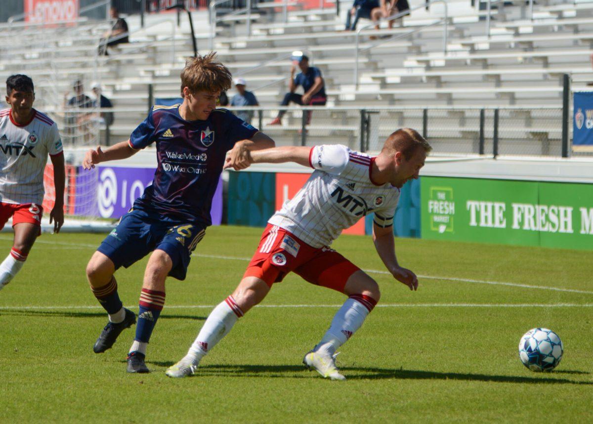 North Carolina FC forward Cole Frame struggles to beat North Texas SC defender Derek Waldeck for ball control during the game on Saturday, Sept. 26, 2021 in Sahlen's Stadium at WakeMed Soccer Park. NCFC had 5 interceptions during the game. North Texas SC beat NCFC 1-0.