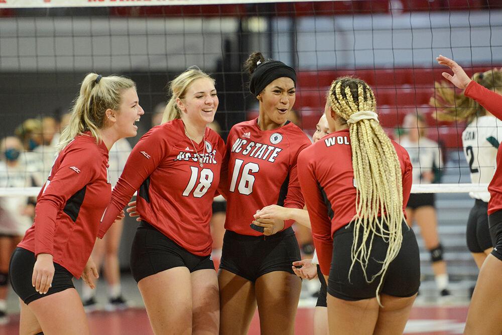 The NC State Wolfpack players, from left, redshirt junior Taylor Rowland (12), freshman Oliwia Durka (18), freshman Jada Allen (16), and graduate student Melissa Evans (3), celebrate scoraing a point against the Coastal Carolina Chanticleers in the first exhibition match of the season in Reynolds Coliseum on Saturday, August 21, 2021. The Chanticleers won the match 3-1.